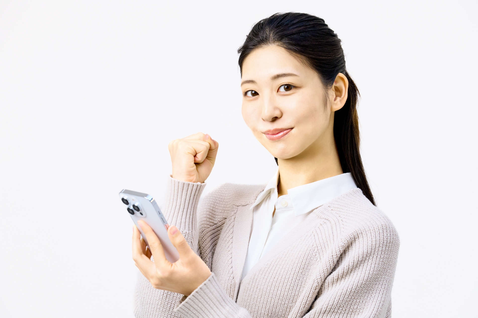 スマホを持ってガッツポーズをする女性